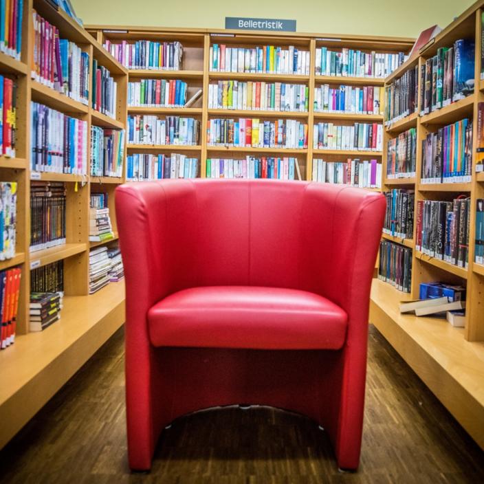 Eine Bücherei von innen, Regale mit Büchern auf drei Seiten, in der Mitte ein roter Sessel (c) kollinger | pixabay.com Eine Bücherei von innen, Regale mit Büchern auf drei Seiten, in der Mitte ein roter Sessel